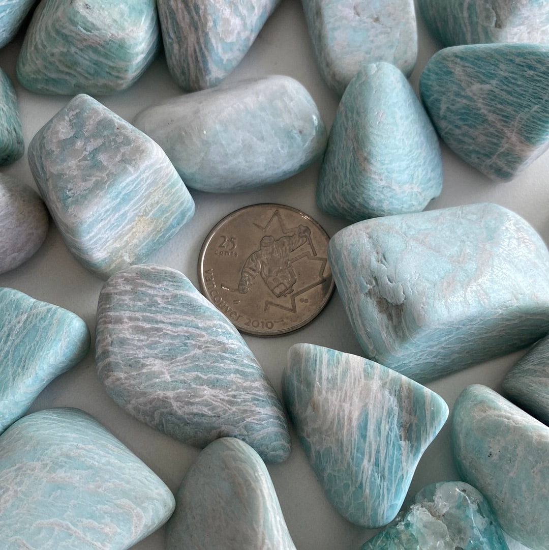 A collection of Amazonite Tumbled stones showcasing their unique pale aqua colors and smooth surfaces, perfect for healing and jewelry.