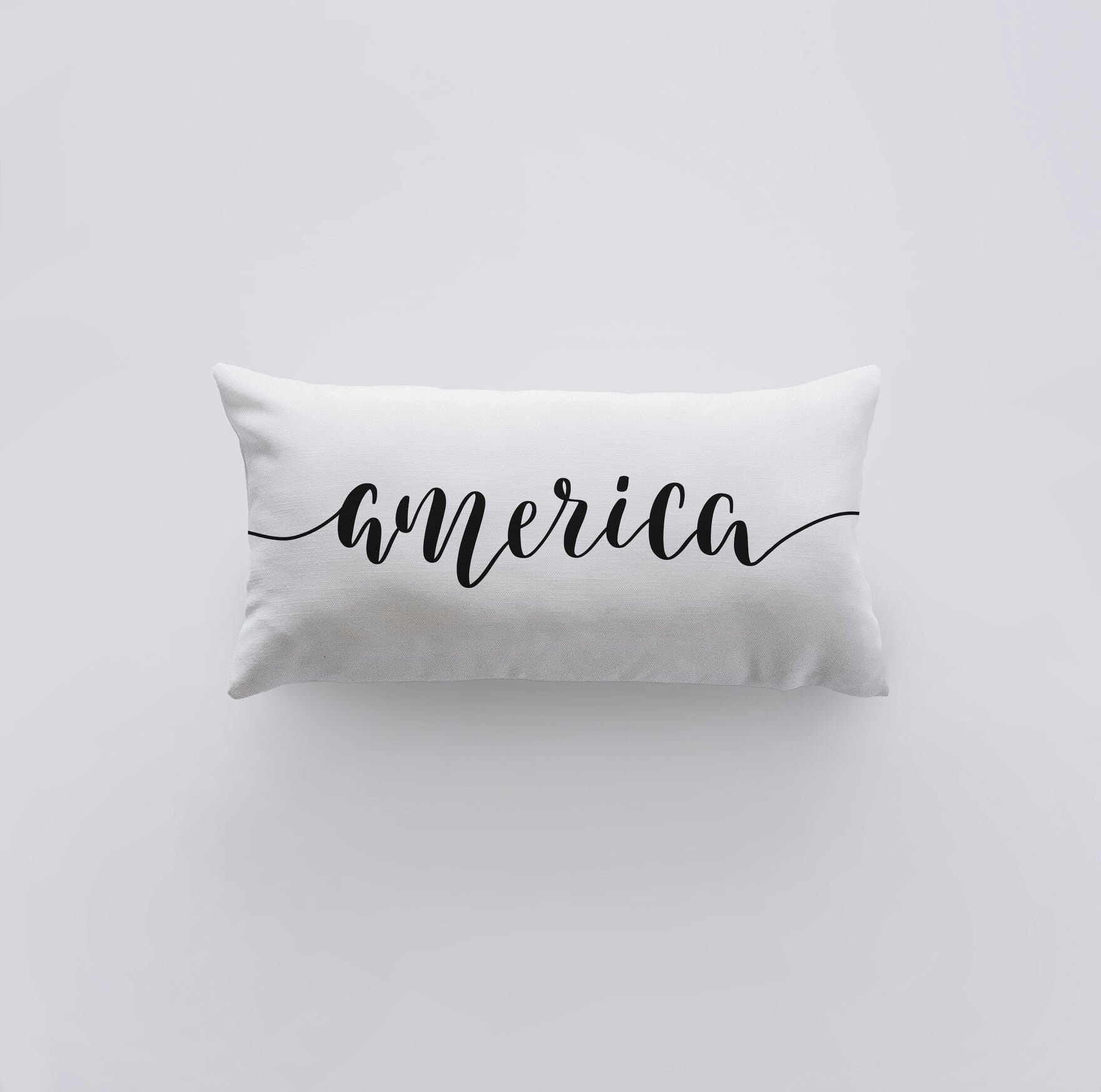 Hand-made America Pillow Cover featuring the word 'America' on the front, measuring 20x10 inches, made from a durable cotton/polyester blend.