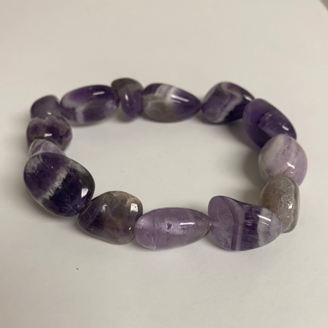 A beautifully polished Amethyst Bracelet featuring unique stones on an elastic band, radiating positive energy.