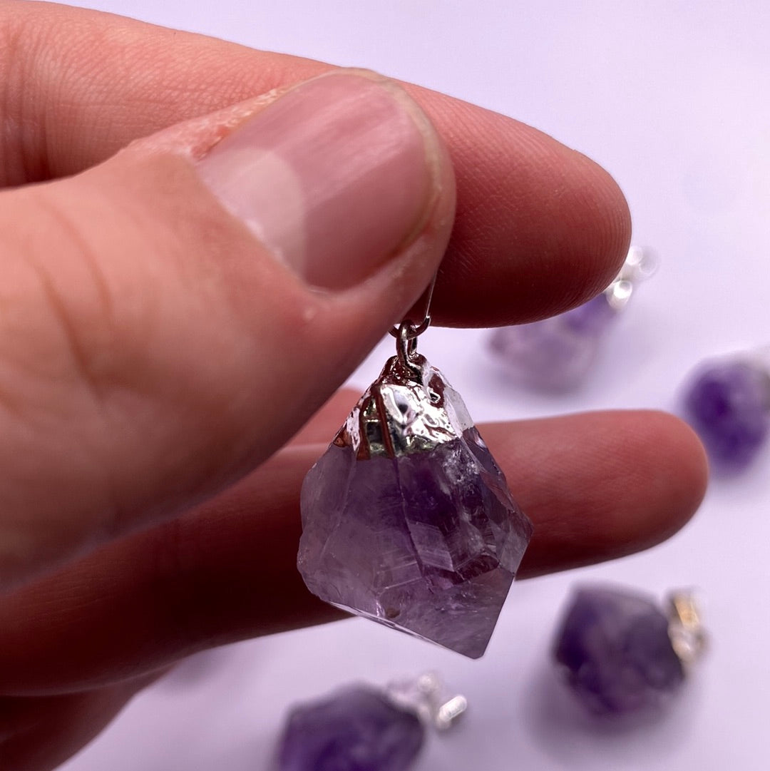 A stunning 1-inch amethyst electroplated point with a vibrant purple hue, showcasing its natural beauty and shine.