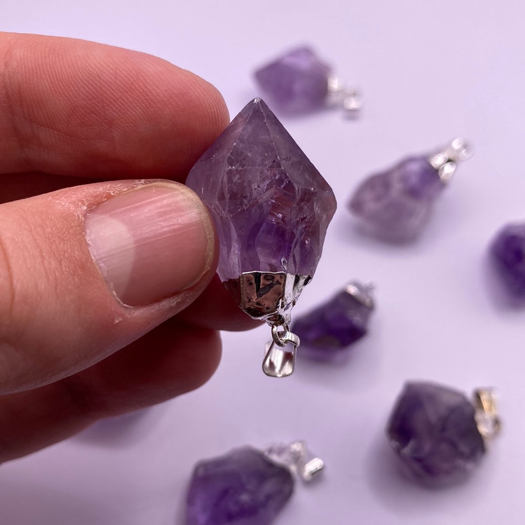 A stunning 1-inch amethyst electroplated point with a vibrant purple hue, showcasing its natural beauty and shine.