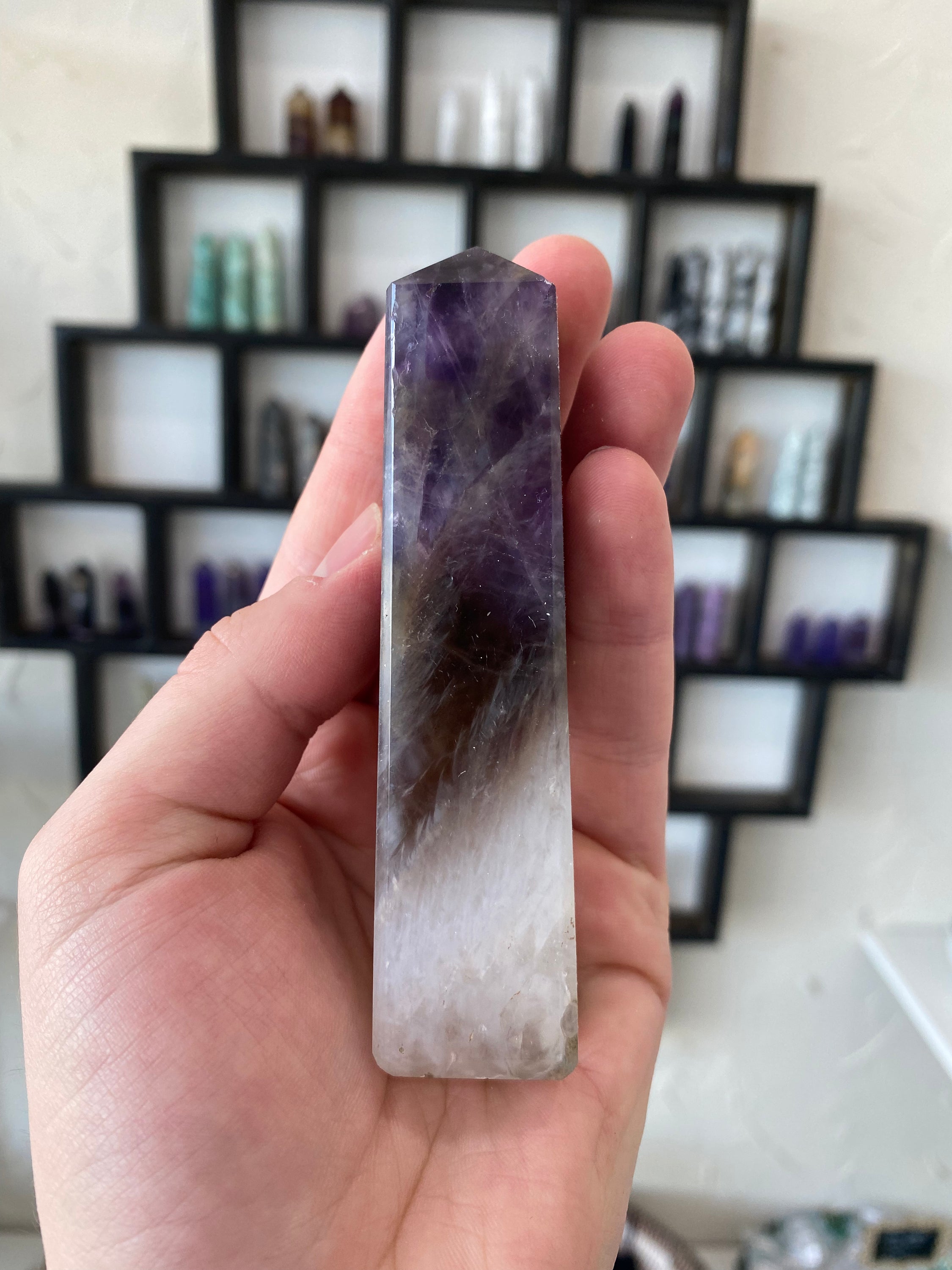 A stunning Amethyst Obelisk with a natural purple sheen, showcasing its hexagonal crystal structure and elegant design.