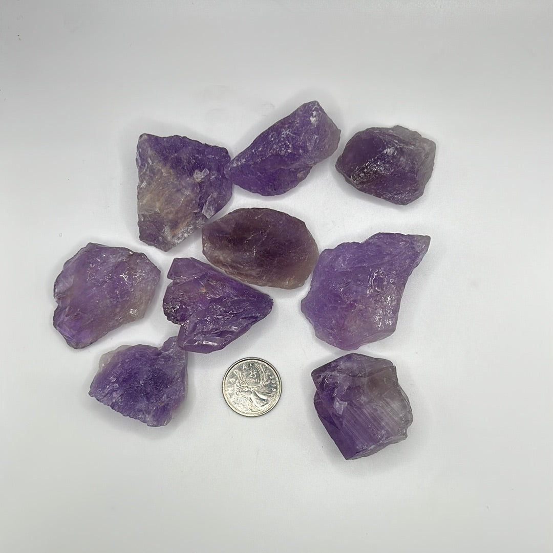 A collection of raw, unpolished amethyst gemstones showcasing their natural purple hues and unique textures, ideal for jewelry-making.