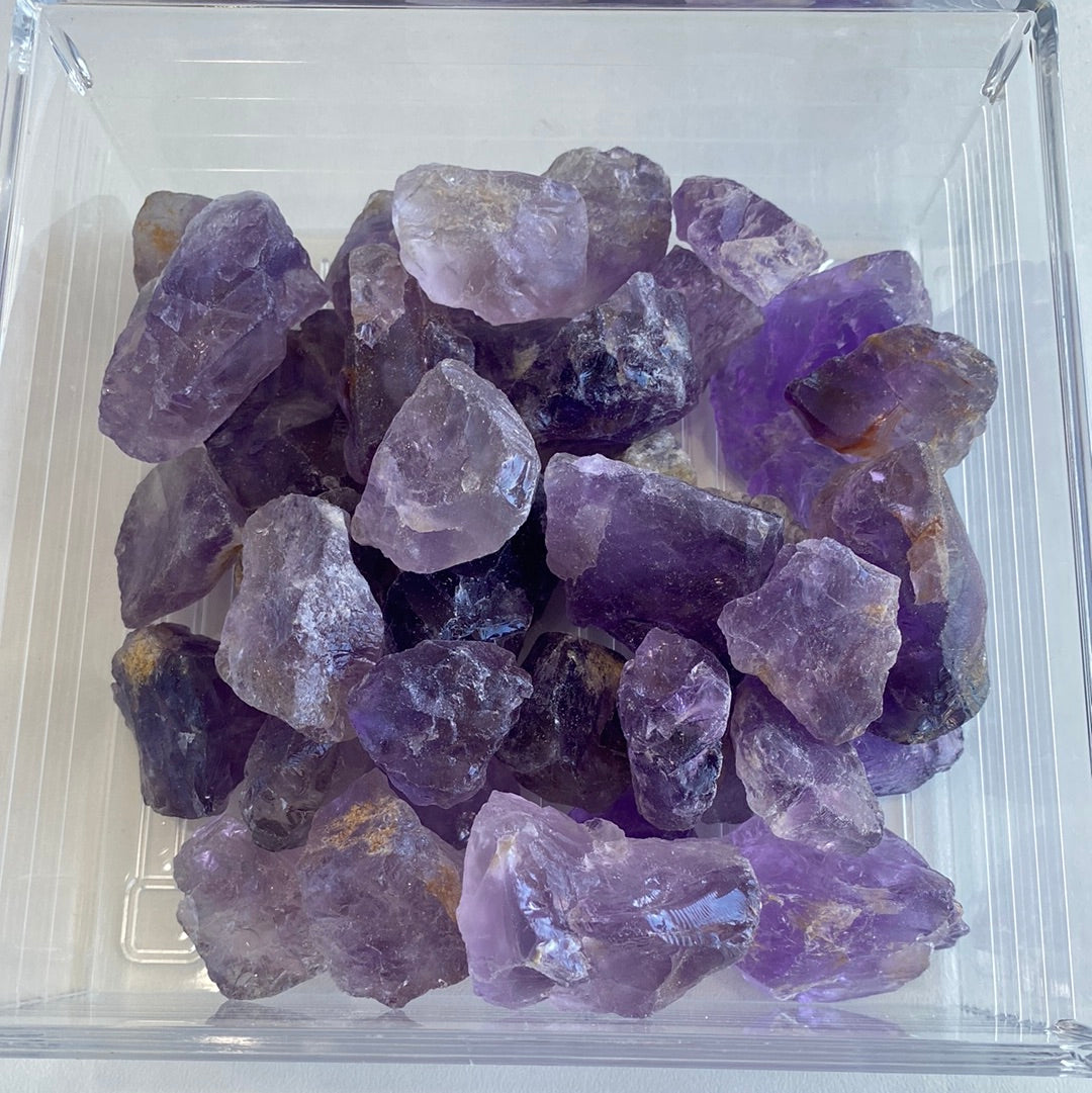 A collection of premium rough cut Amethyst stones, showcasing their natural purple hues and unique shapes, measuring approximately 1-2 inches.