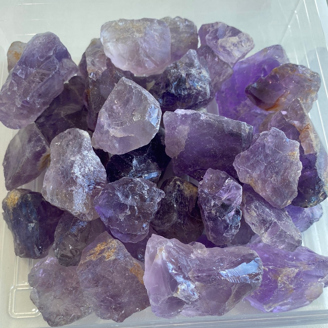 A collection of premium rough cut Amethyst stones, showcasing their natural purple hues and unique shapes, measuring approximately 1-2 inches.