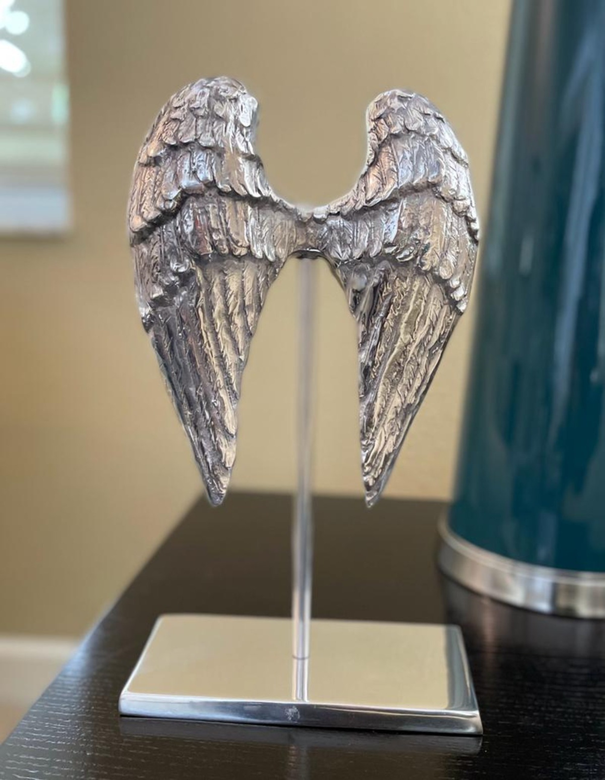 Elegant silvery angel wings sculpture made from recycled aluminum, perfect for modern home decor.