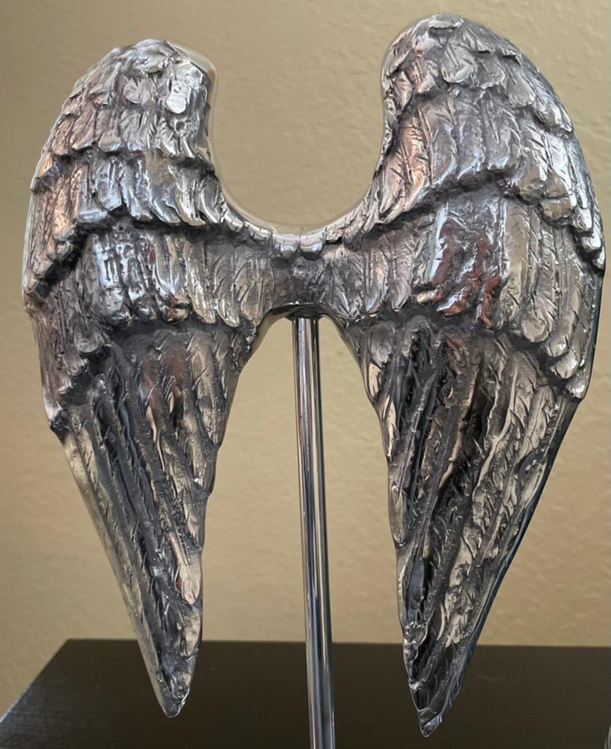 Elegant silvery angel wings sculpture made from recycled aluminum, perfect for modern home decor.