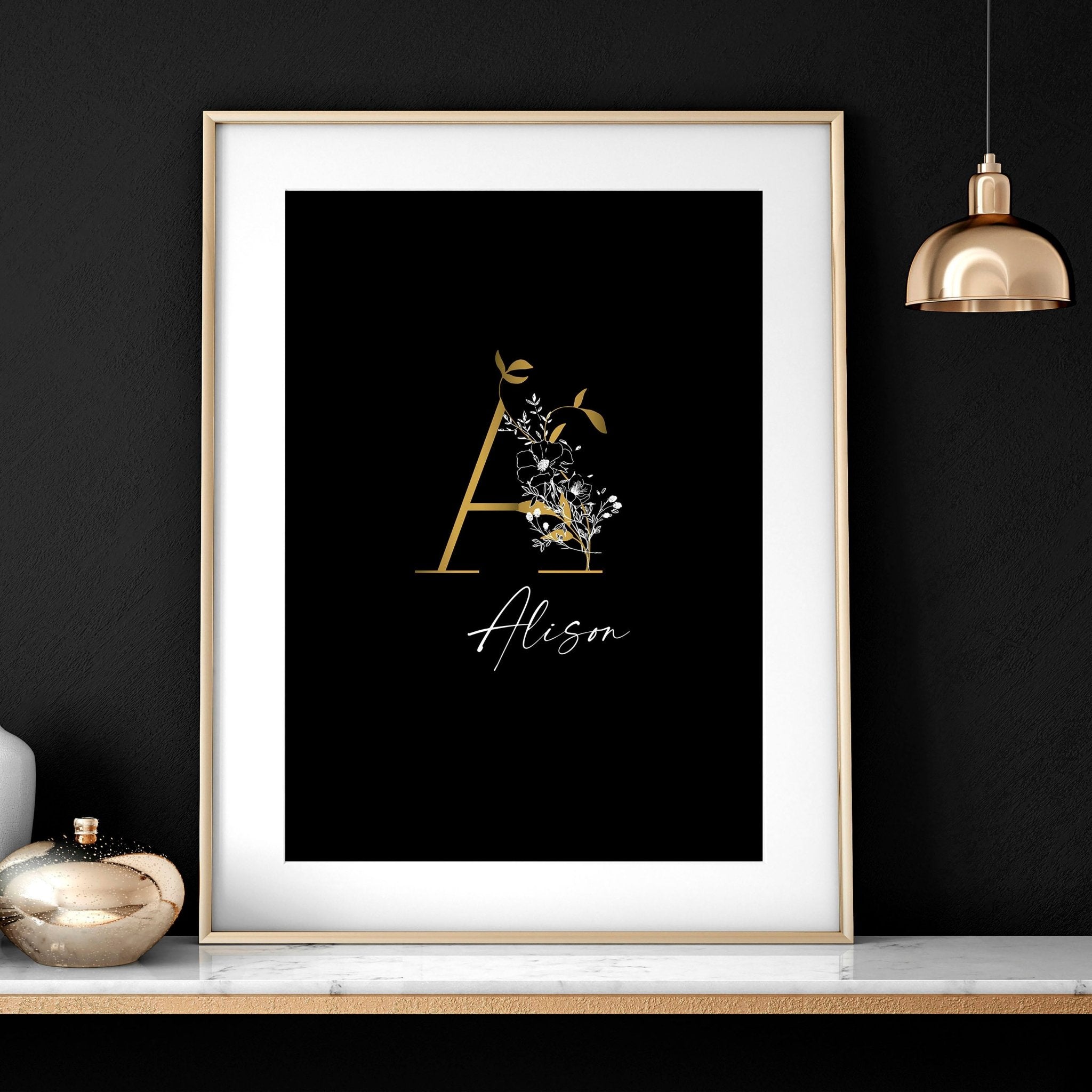 Set of 3 personalized wall art prints featuring botanical monogram designs in white, black, and gold on a black background.