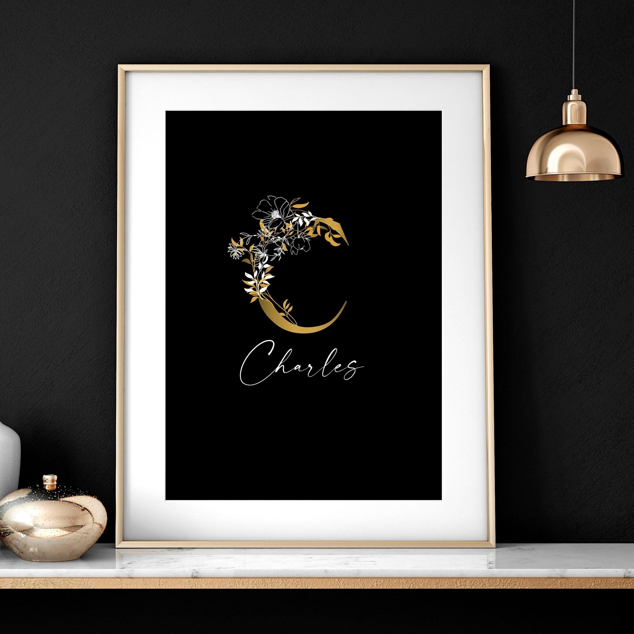 Set of 3 personalized wall art prints featuring botanical monogram designs in white, black, and gold on a black background.