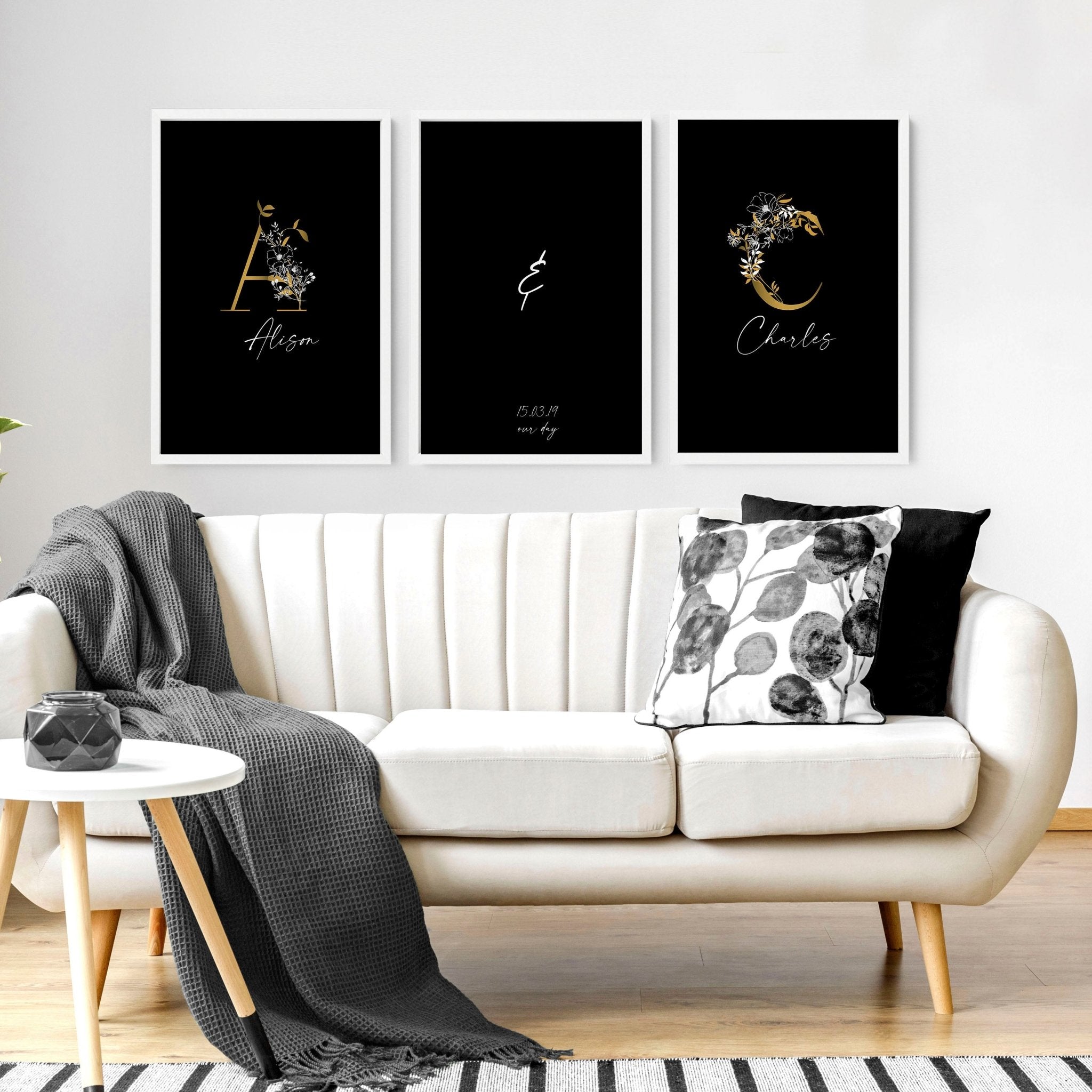 Set of 3 personalized wall art prints featuring botanical monogram designs in white, black, and gold on a black background.