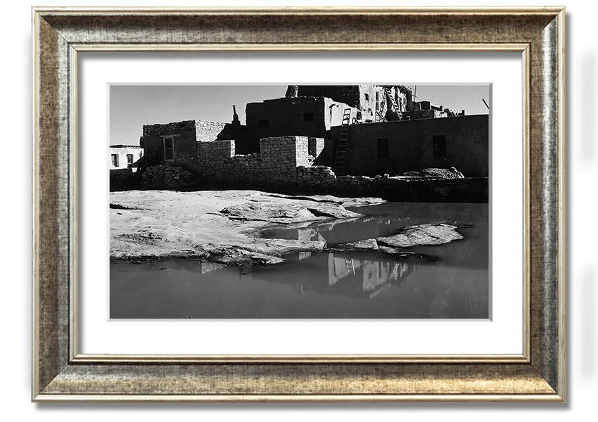 Framed print of Ansel Adams' Acoma Pueblo 3, showcasing intricate adobe structures and dramatic sky.