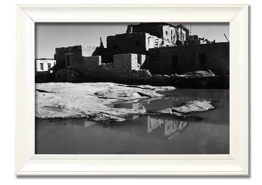 Framed print of Ansel Adams' Acoma Pueblo 3, showcasing intricate adobe structures and dramatic sky.