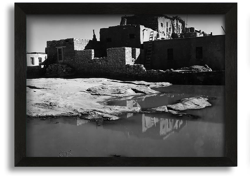 Framed print of Ansel Adams' Acoma Pueblo 3, showcasing intricate adobe structures and dramatic sky.