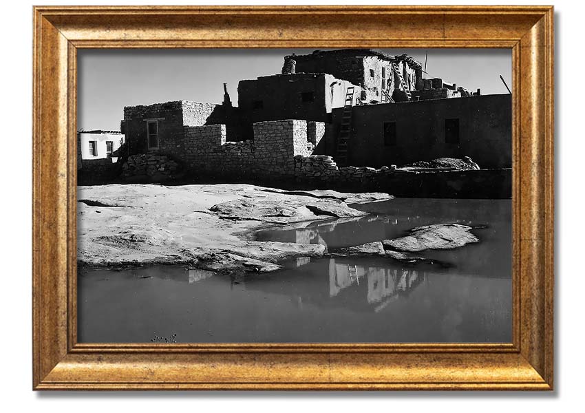 Framed print of Ansel Adams' Acoma Pueblo 3, showcasing intricate adobe structures and dramatic sky.