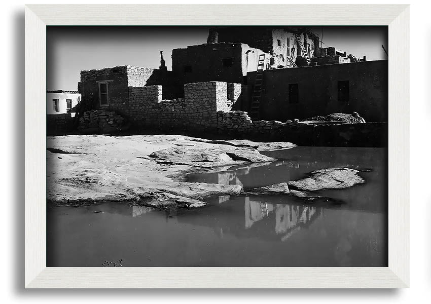 Framed print of Ansel Adams' Acoma Pueblo 3, showcasing intricate adobe structures and dramatic sky.