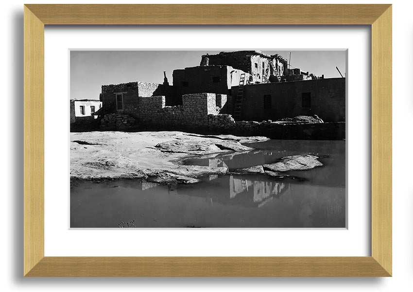 Framed print of Ansel Adams' Acoma Pueblo 3, showcasing intricate adobe structures and dramatic sky.