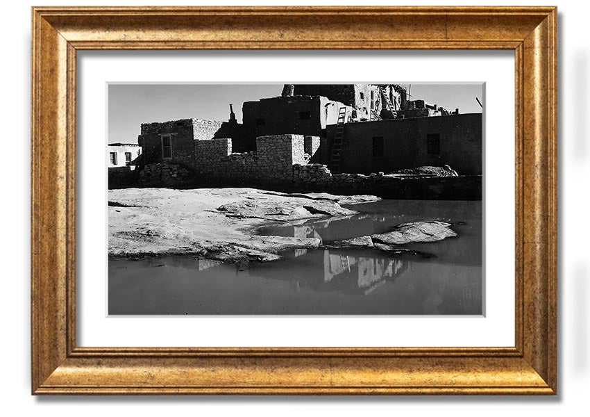 Framed print of Ansel Adams' Acoma Pueblo 3, showcasing intricate adobe structures and dramatic sky.