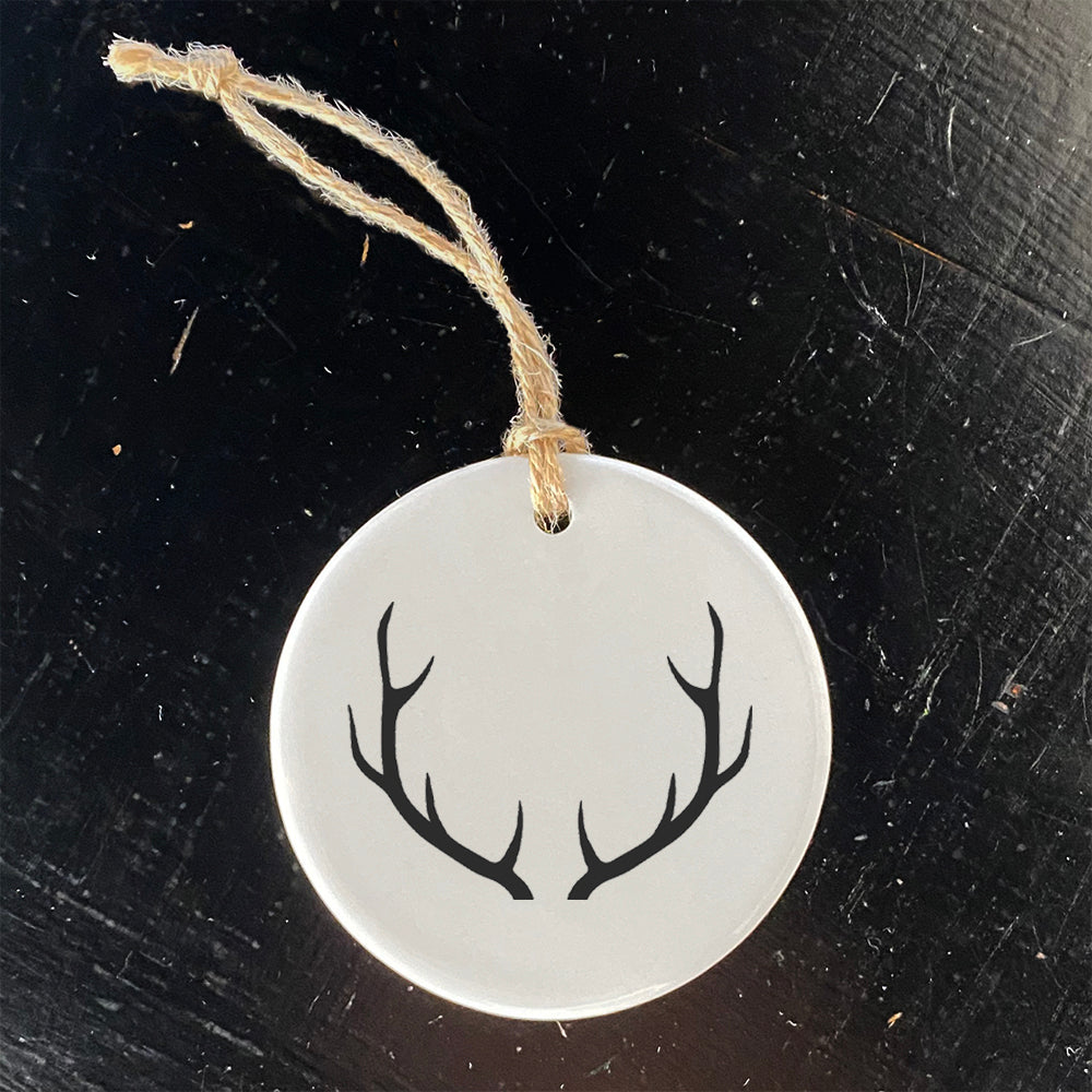 A beautifully crafted porcelain ornament featuring antlers design, perfect for holiday decor or as a gift tag.