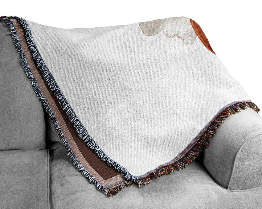 A luxurious Apple Half throw blanket made from 100% cotton, featuring a thermal weave for breathability, draped elegantly over a couch.