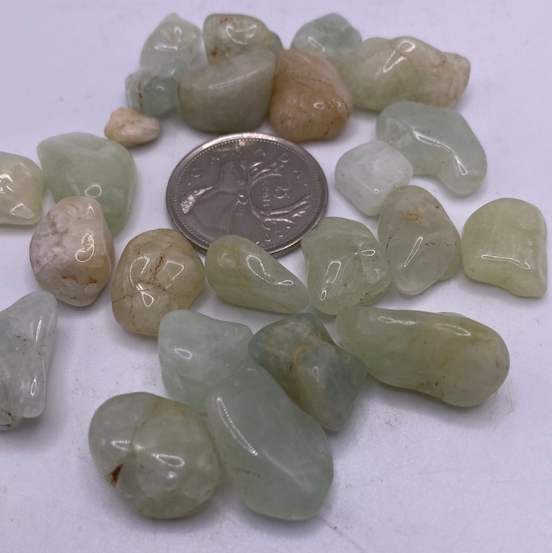 A 45g bag of polished Aquamarine Tumbled stones showcasing light blue and green hues.