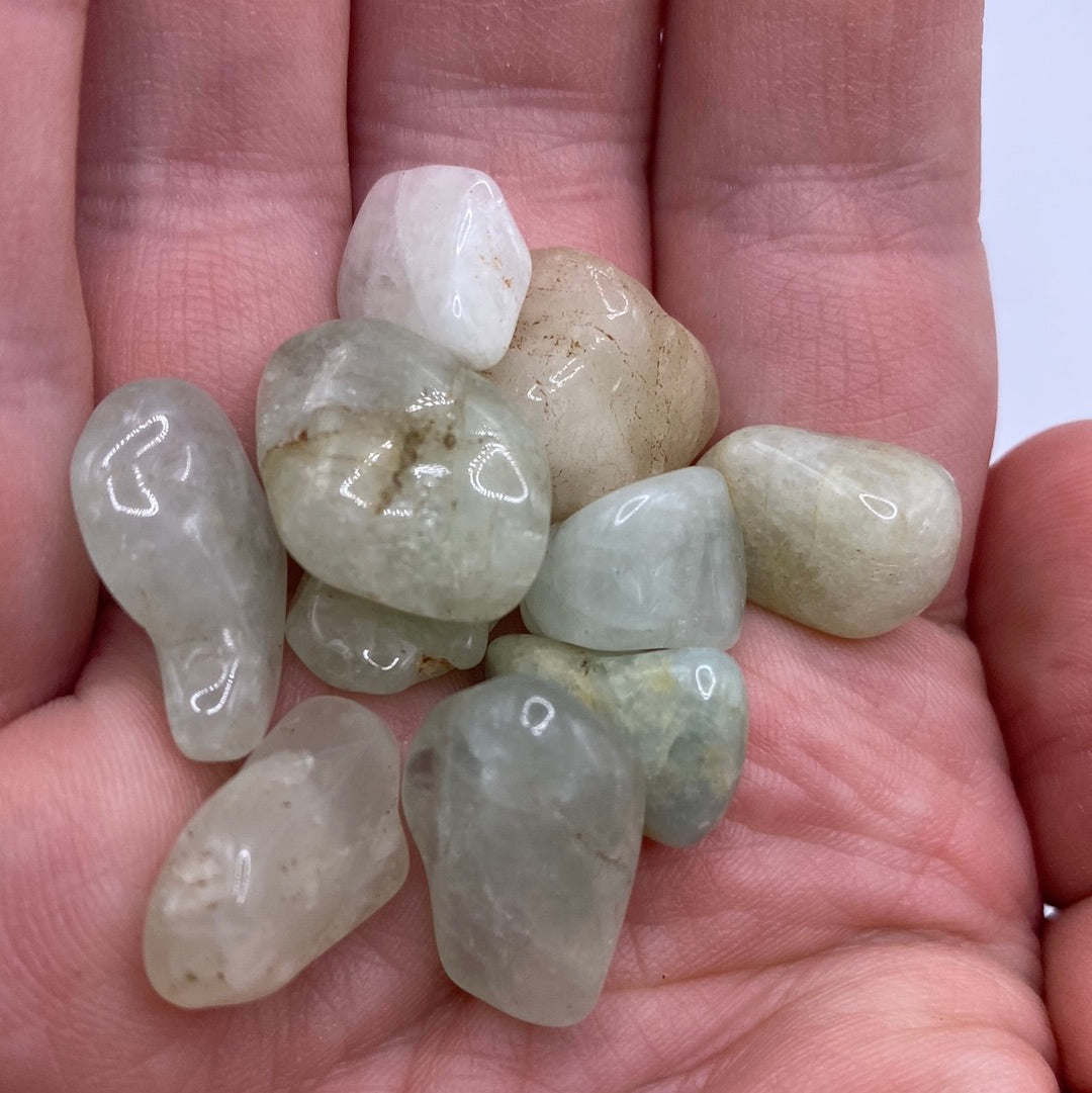 A 45g bag of polished Aquamarine Tumbled stones showcasing light blue and green hues.