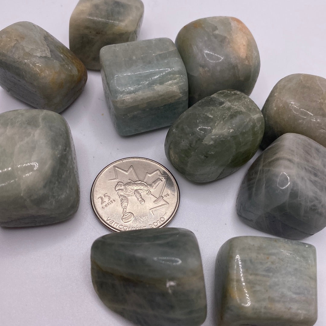 A collection of smooth, blue-green Aquamarine Tumbled stones, showcasing their natural beauty and calming energy.