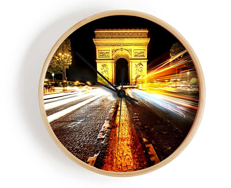 A stylish bamboo clock featuring the Arc De Triomphe illuminated at night, showcasing its round face and clear Plexiglas lens.