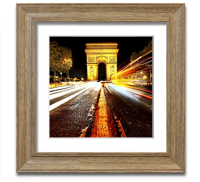 A beautifully framed print of the Arc De Triomphe illuminated at night, showcasing its architectural details and vibrant colors.