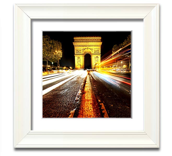 A beautifully framed print of the Arc De Triomphe illuminated at night, showcasing its architectural details and vibrant colors.