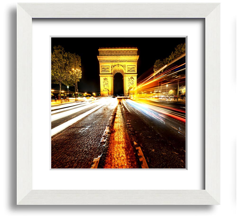 A beautifully framed print of the Arc De Triomphe illuminated at night, showcasing its architectural details and vibrant colors.