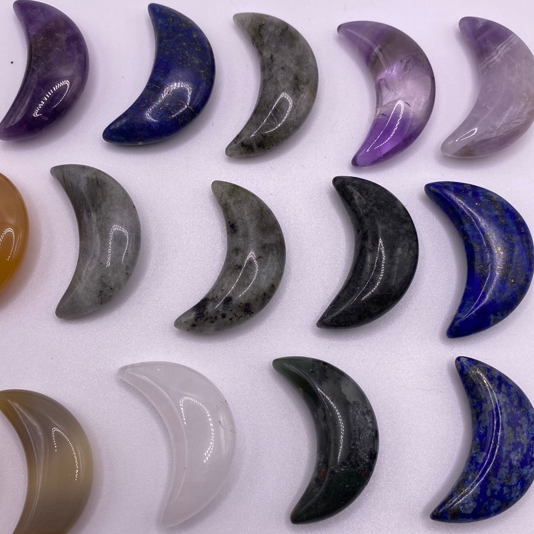 A collection of assorted mini moons made from various crystals including Lapis Lazuli, Amethyst, and Clear Quartz, each approximately 1 inch in size.