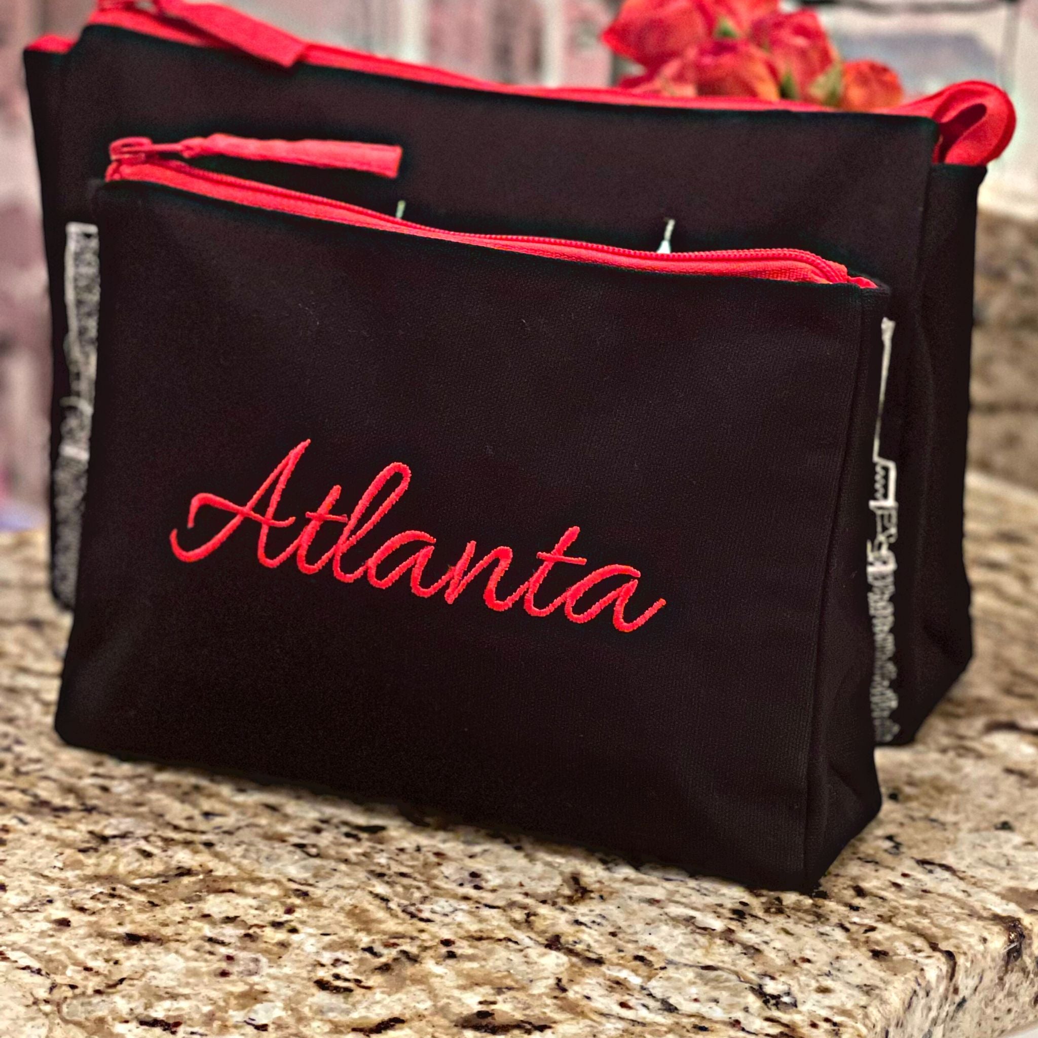 Atlanta Makeup Bag set featuring embroidered skyline design on cream and black cotton canvas with red waterproof lining.