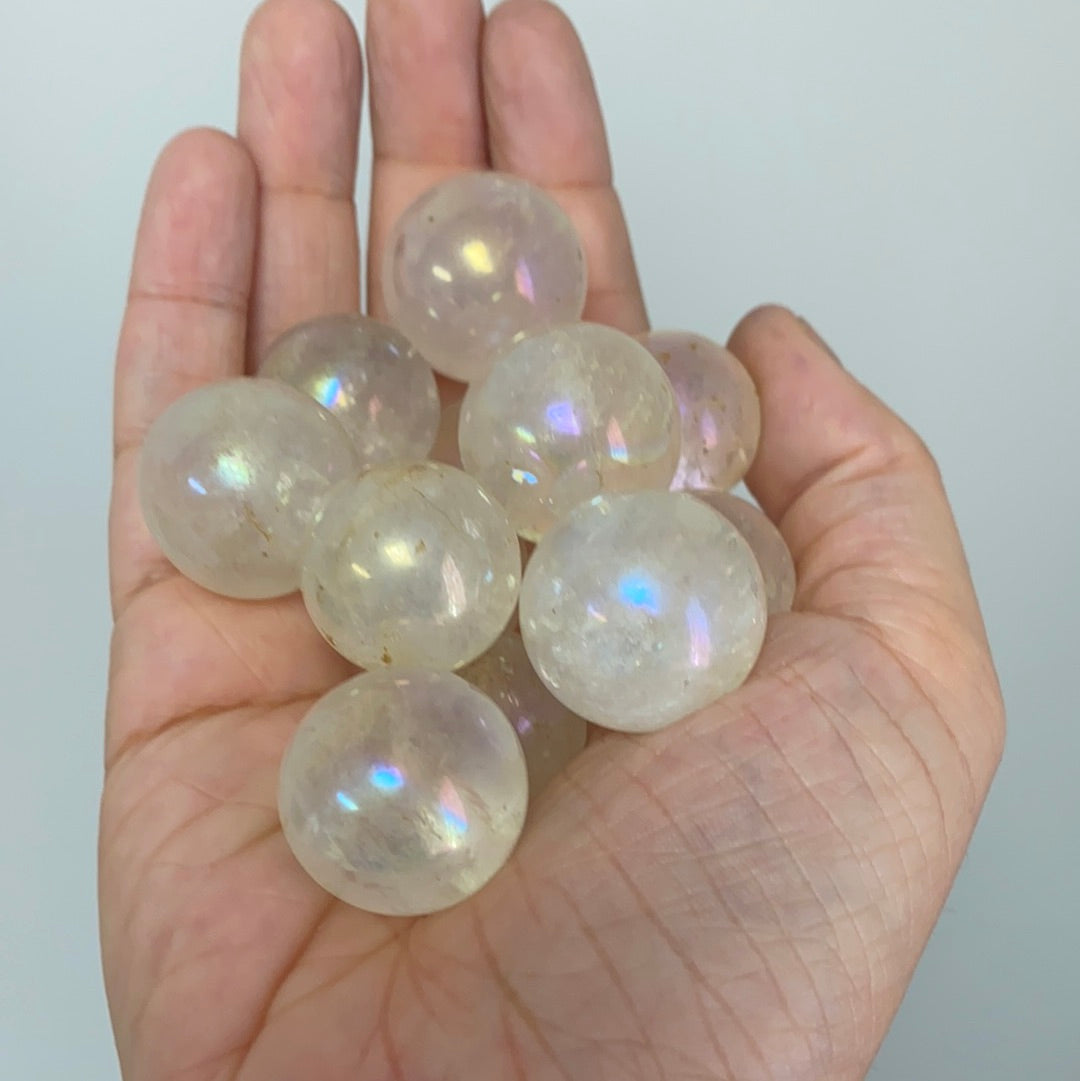 A vibrant Aura Quartz Mini Sphere approximately 1 inch in diameter, showcasing its iridescent colors and unique patterns.