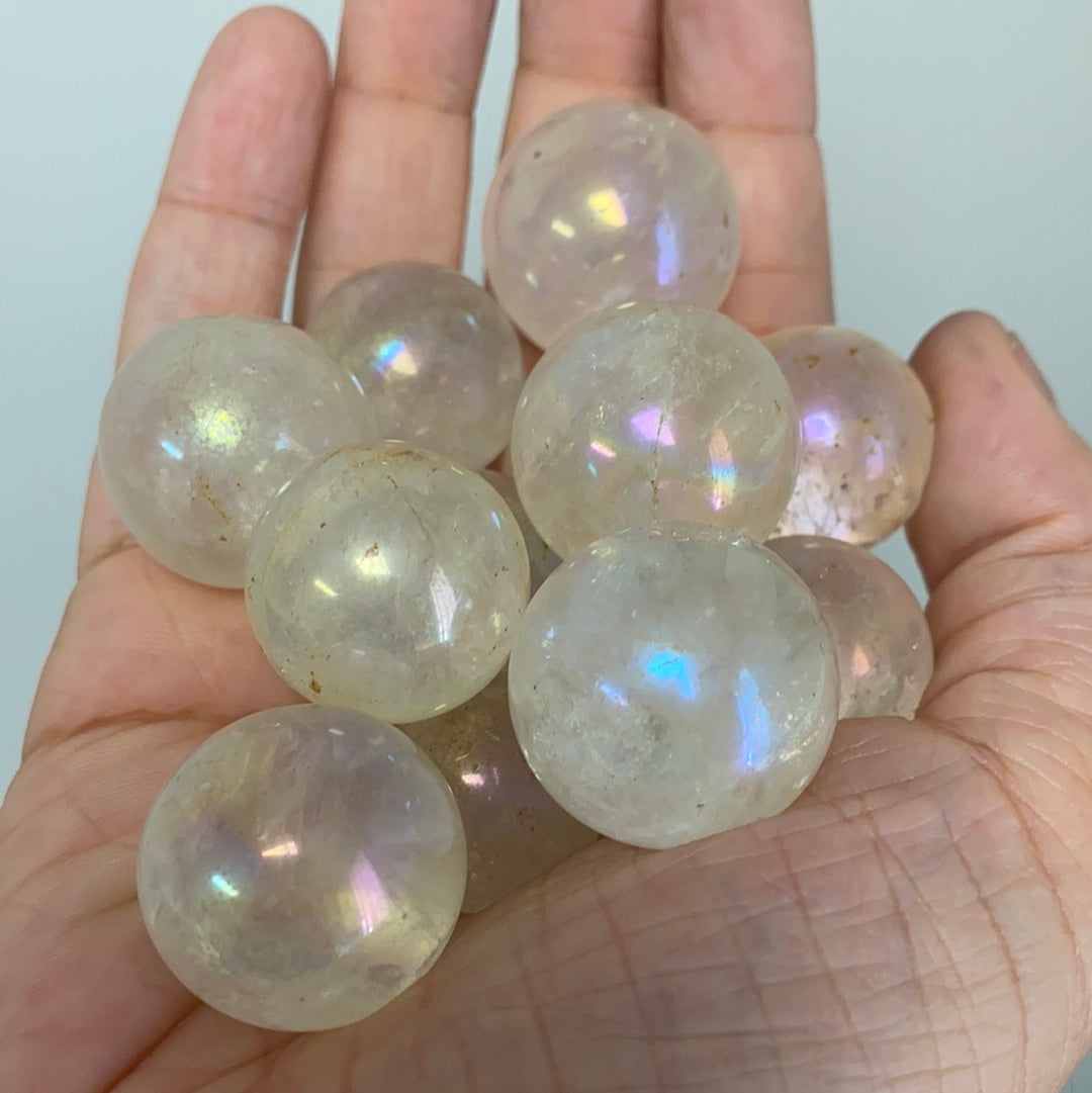 A vibrant Aura Quartz Mini Sphere approximately 1 inch in diameter, showcasing its iridescent colors and unique patterns.