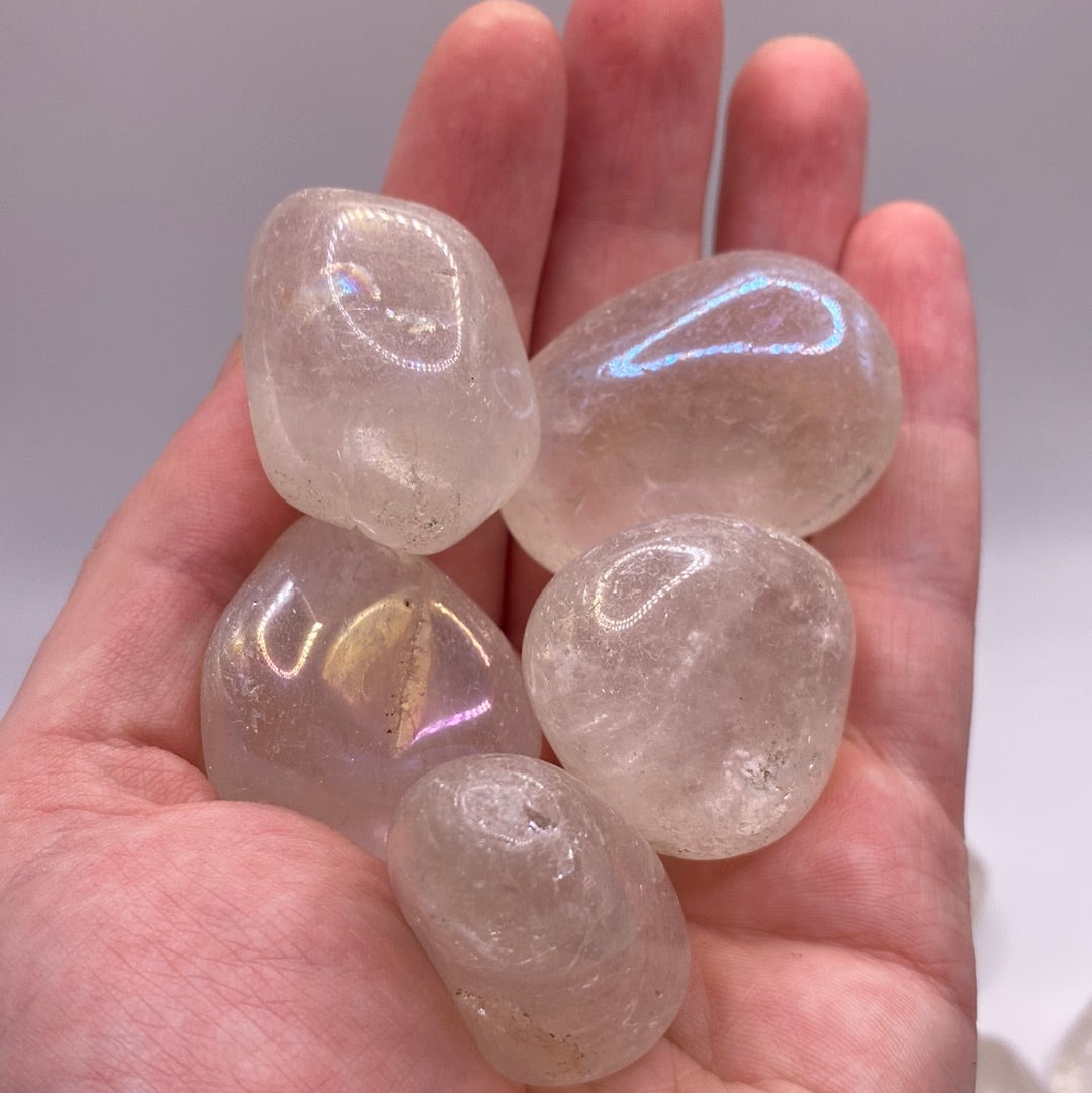 Aura Quartz Tumbled Stone (L) showcasing its iridescent colors and smooth surface, radiating positive energy.