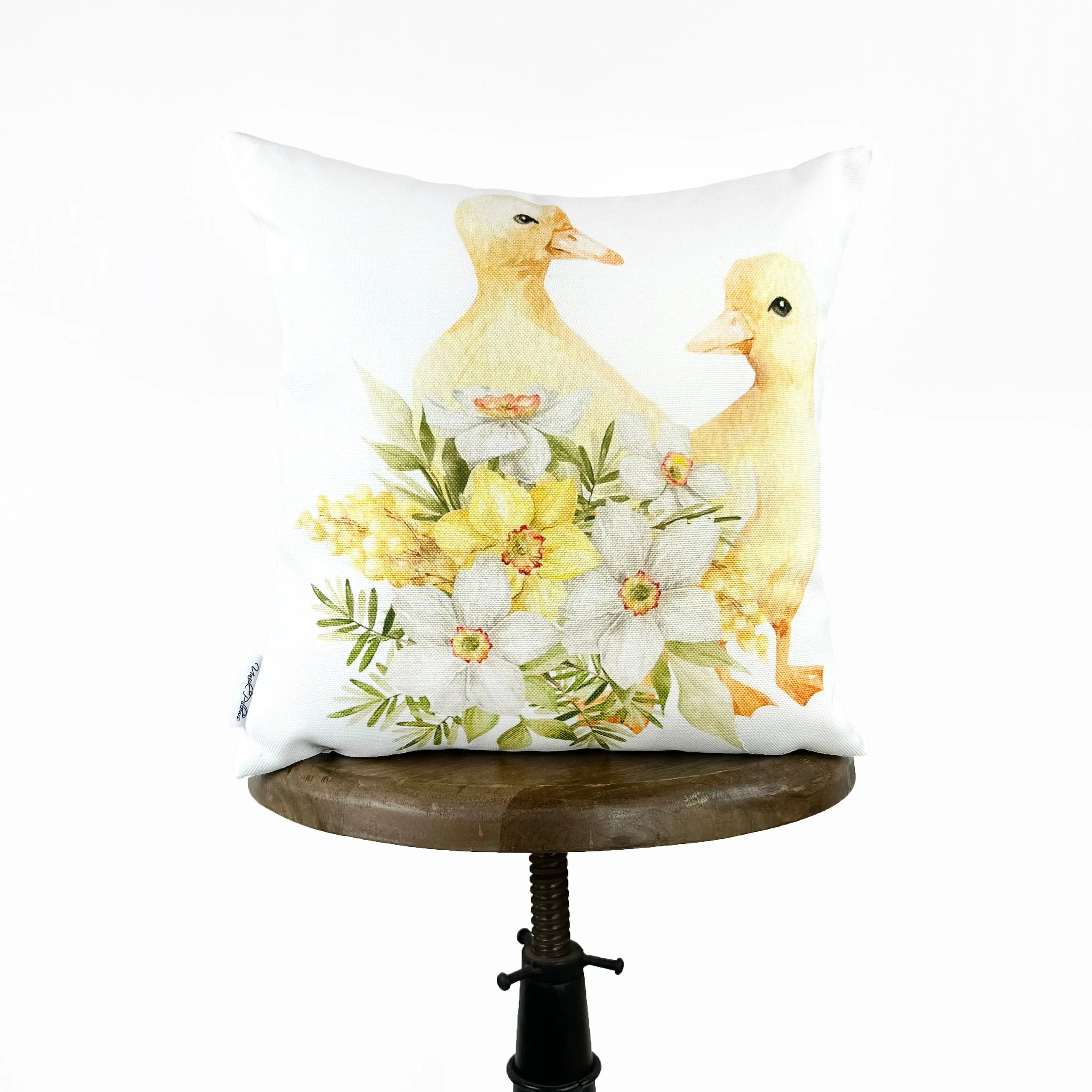 A vibrant accent pillow featuring baby ducks surrounded by colorful flowers, perfect for Spring and Easter décor.