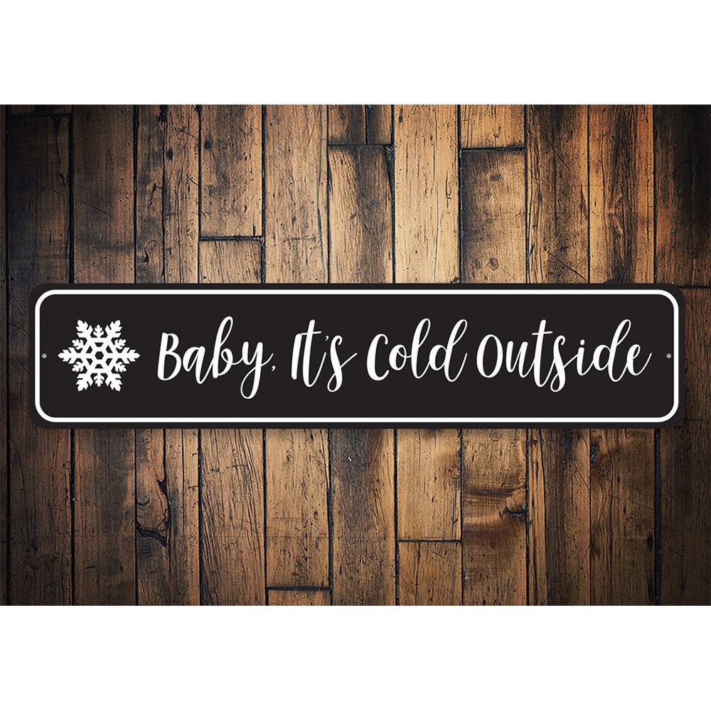 A decorative Baby It's Cold Outside Sign made of high-quality aluminum, featuring festive colors and a charming design, perfect for Christmas decorations.