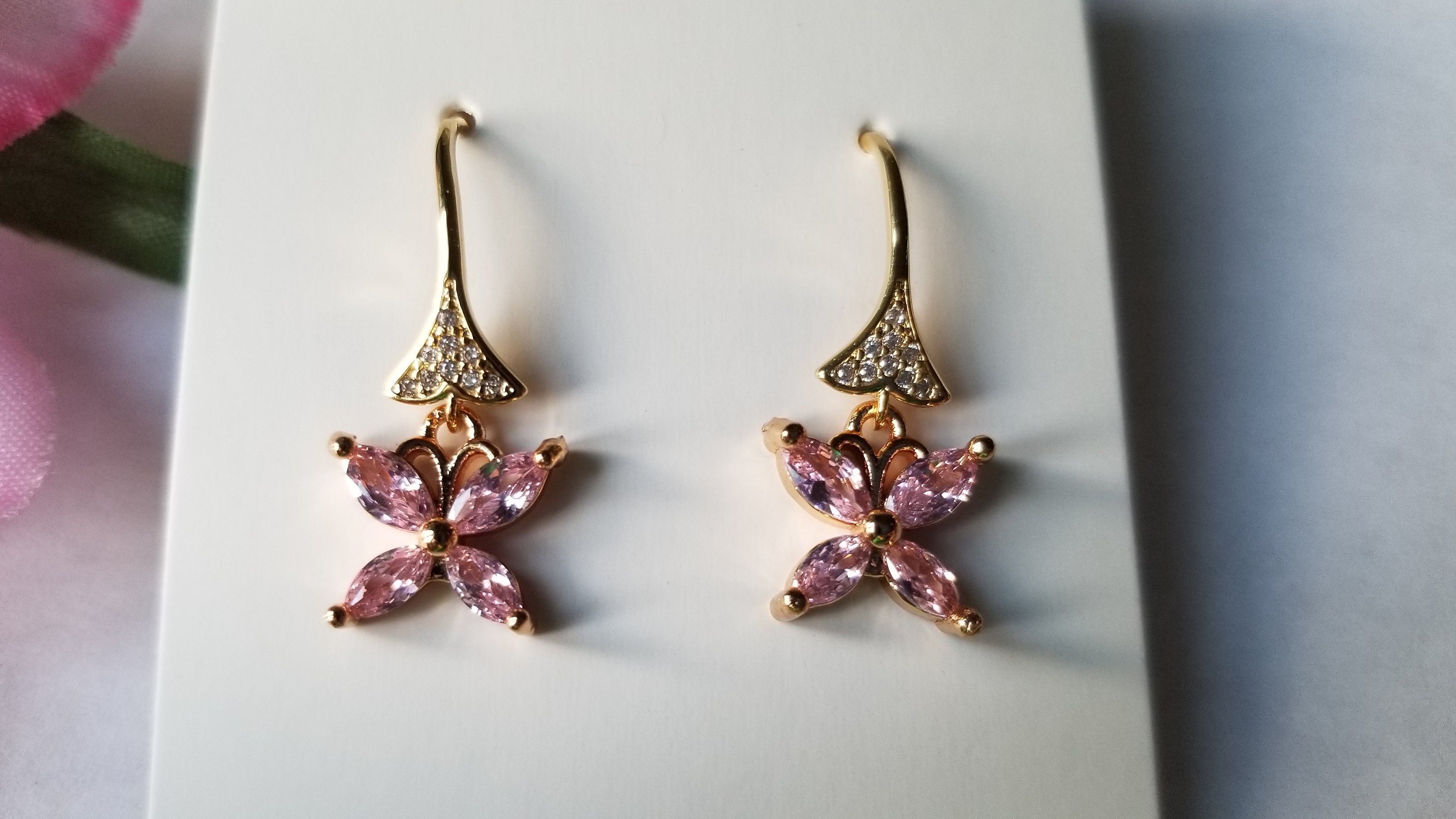 A pair of elegant baby pink butterfly earrings, beautifully crafted with 18K gold plating, showcasing intricate details and a charming design.