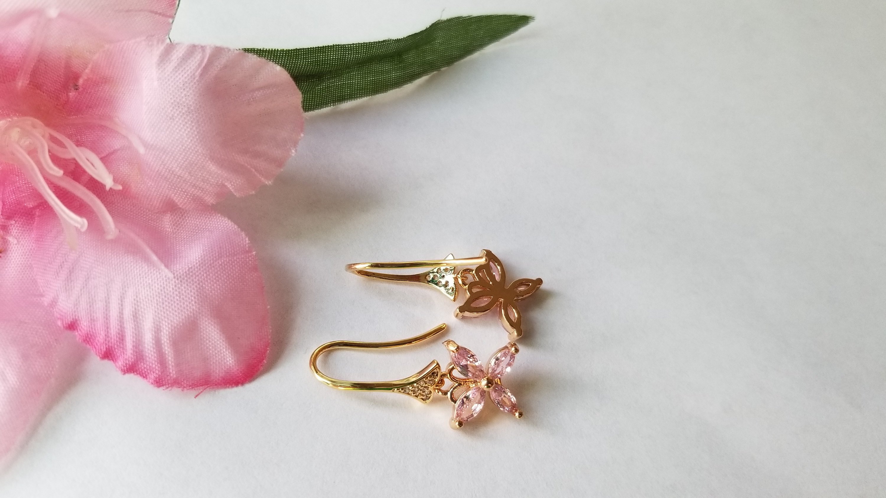 A pair of elegant baby pink butterfly earrings, beautifully crafted with 18K gold plating, showcasing intricate details and a charming design.