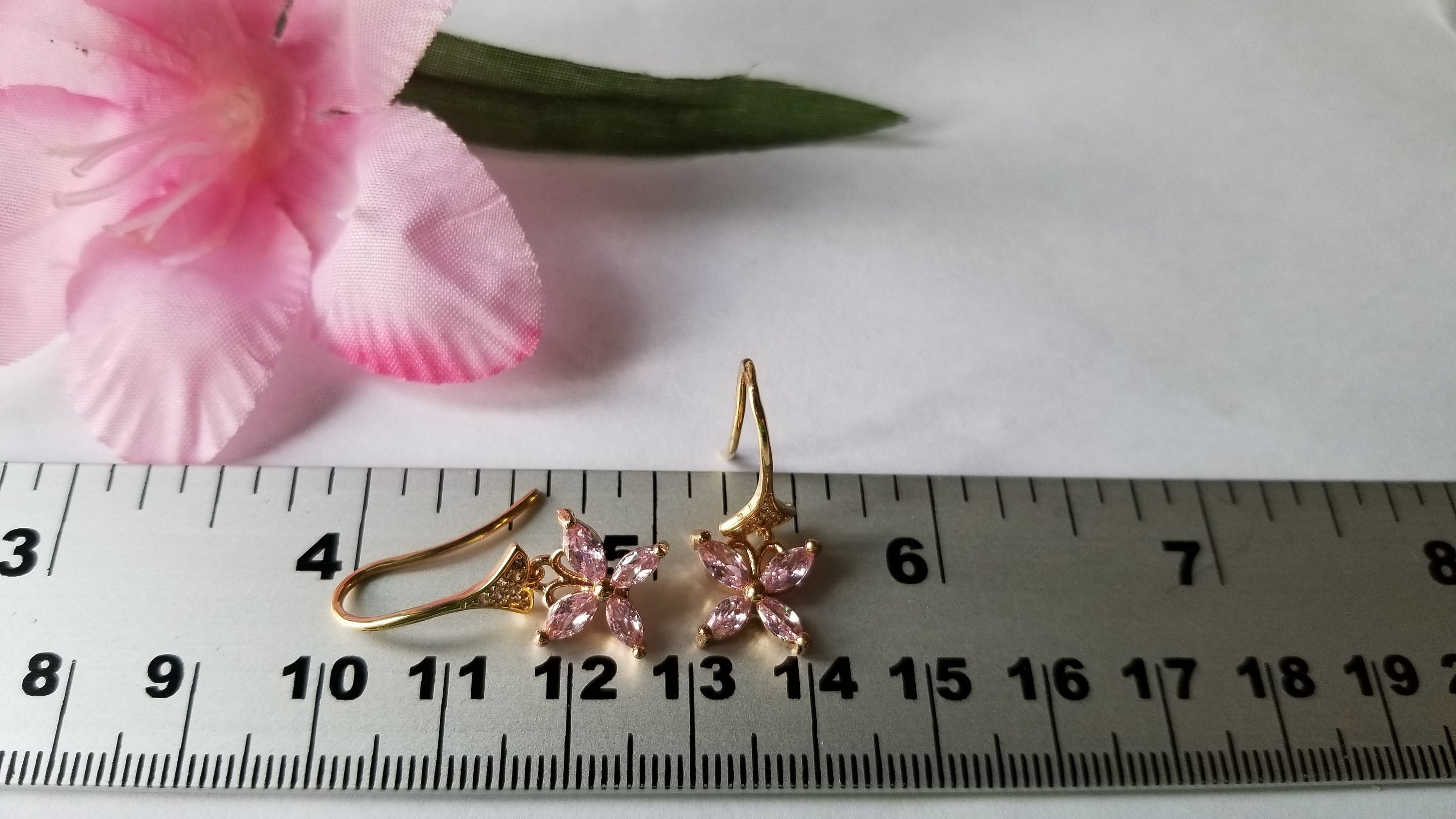 A pair of elegant baby pink butterfly earrings, beautifully crafted with 18K gold plating, showcasing intricate details and a charming design.