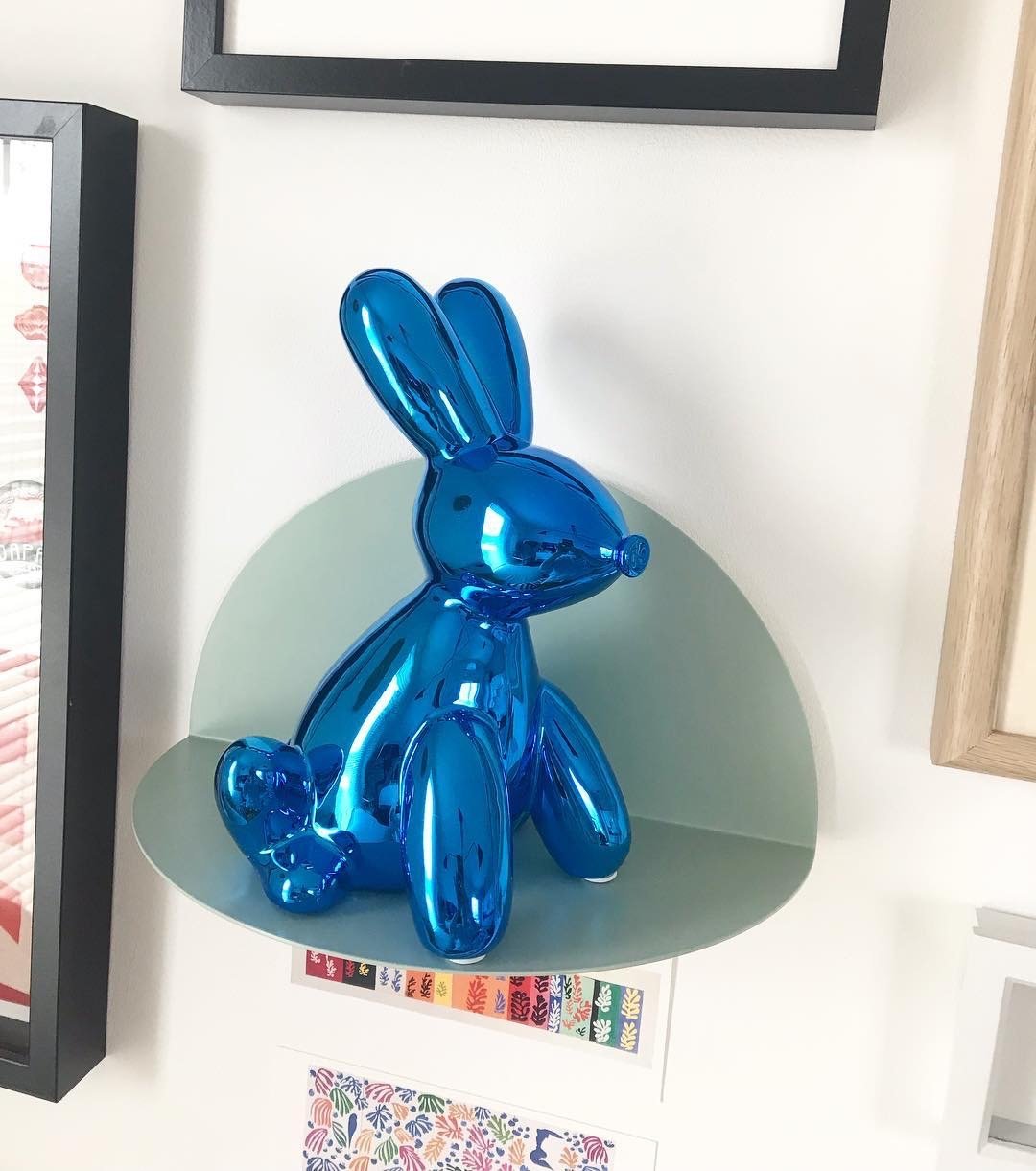 A glossy ceramic balloon bunny money bank in vibrant colors, featuring pink ears and a cheerful smile, perfect for saving coins.