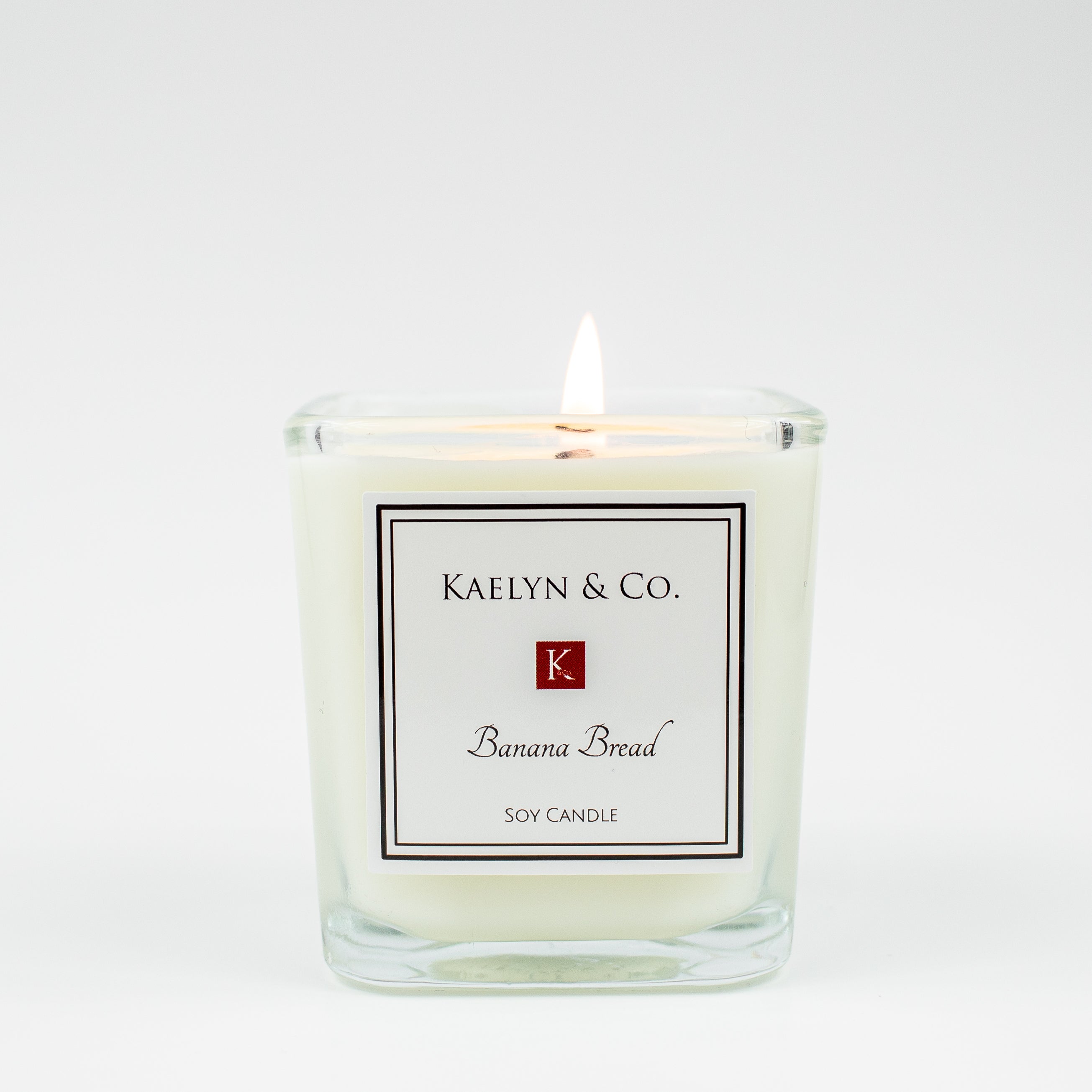 A small cube candle with a banana bread scent, featuring a warm, inviting design and eco-friendly packaging.