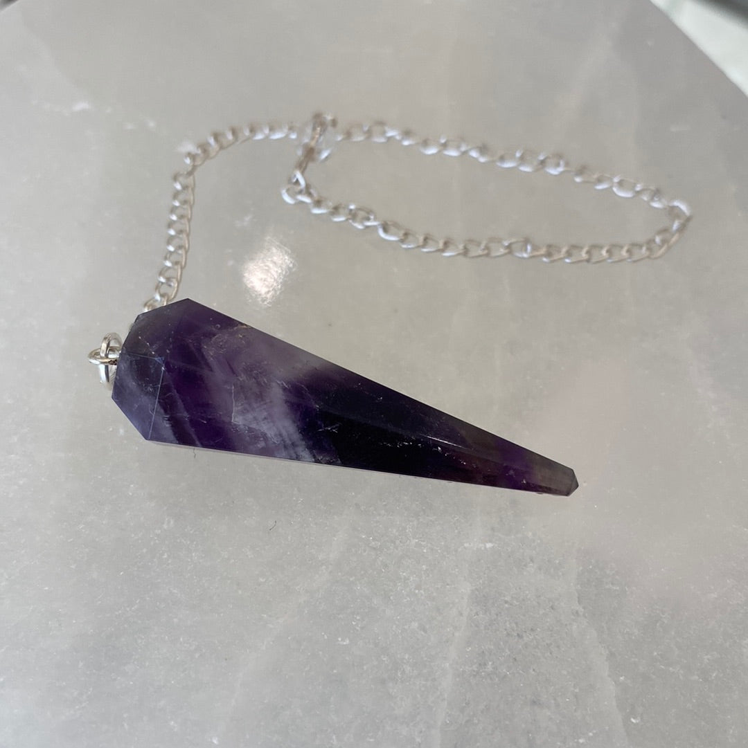 A beautiful Banded Amethyst Pendulum showcasing unique purple hues, perfect for spiritual practices and collections.