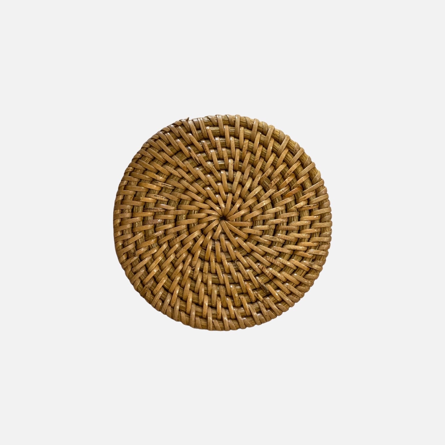 Natural rattan placemat with a unique spiraling design, enhancing the dining table's aesthetic.