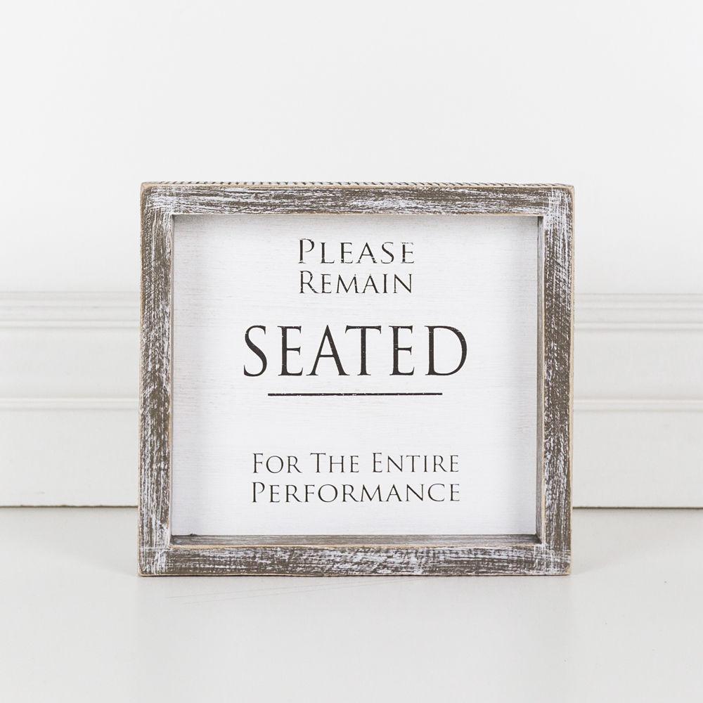 A versatile wood sign displaying 'Please Remain Seated For The Entire Performance' in black and white, suitable for bathrooms and theaters.