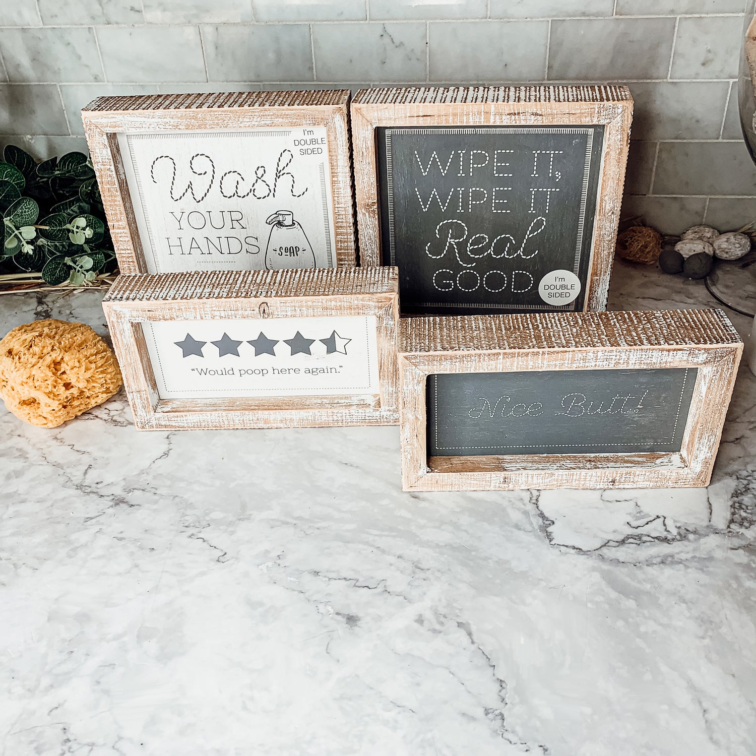 Double-sided bathroom sign featuring humorous quotes, framed in a thick wooden frame, suitable for freestanding or wall display.