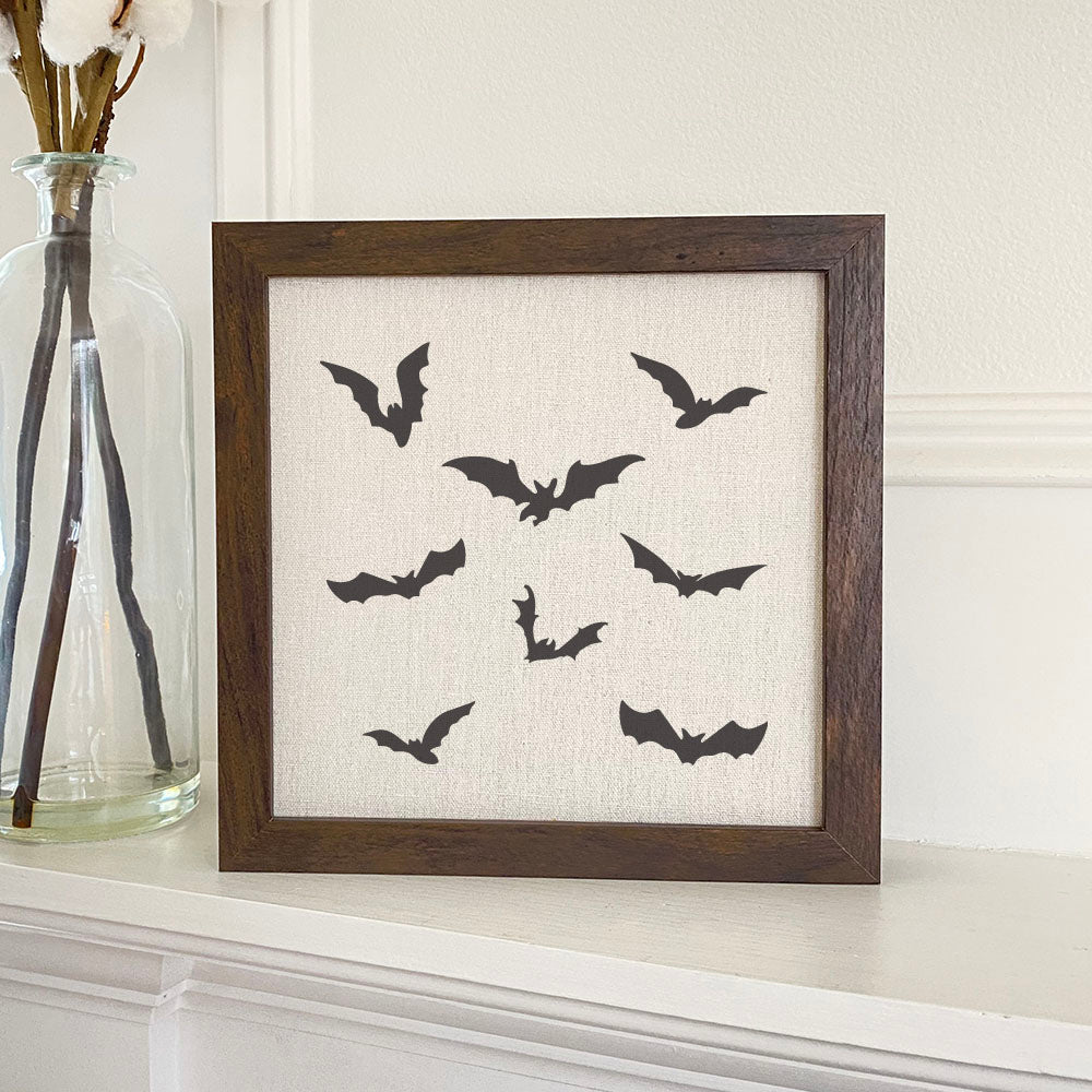 A beautifully framed sign featuring bats, with a natural wood frame and eco-friendly printing on a linen-look background.