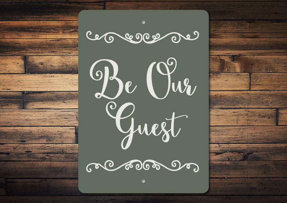 A decorative Be Our Guest Sign made of high-quality aluminum, featuring a welcoming design suitable for indoor and outdoor use.