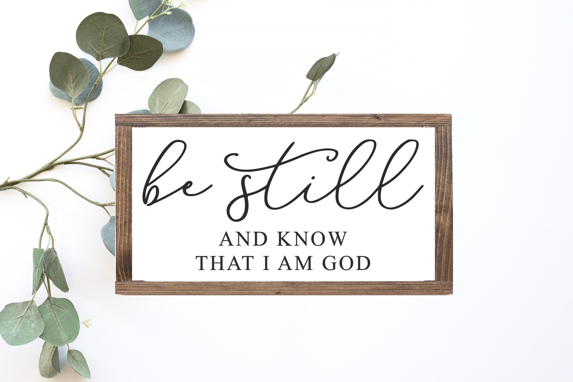 Be Still And Know That I Am God Wood Sign, handmade with a matte white finish and elegant lettering, available in two sizes.