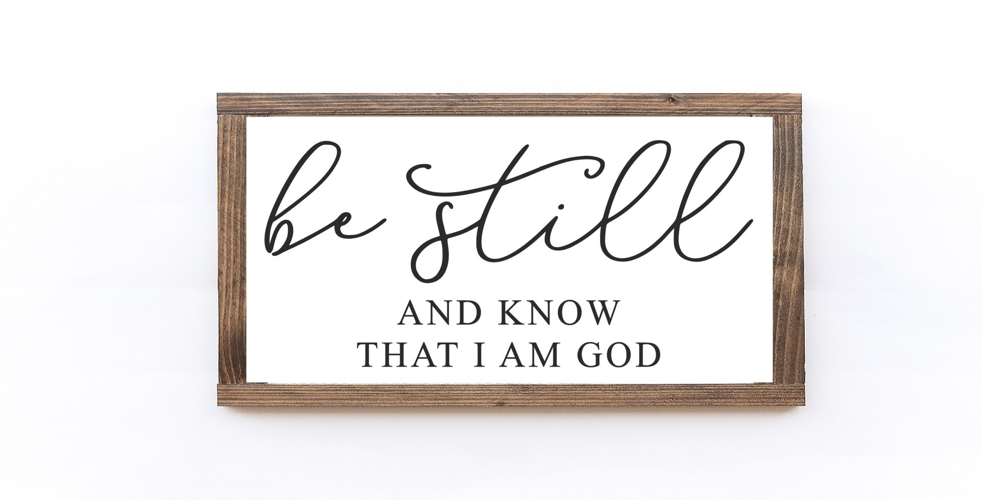 Be Still And Know That I Am God Wood Sign, handmade with a matte white finish and elegant lettering, available in two sizes.